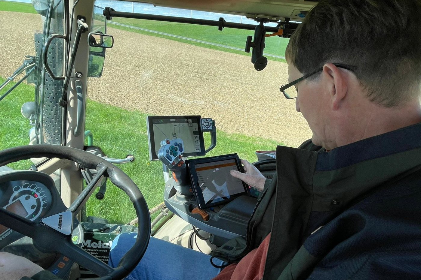 Digitalisierung in der Landwirtschaft: Mann sitzt in einem Traktor mit GPS-Gerät. Klick führt zu Großansicht in Lightbox, Schließen mit ESC.