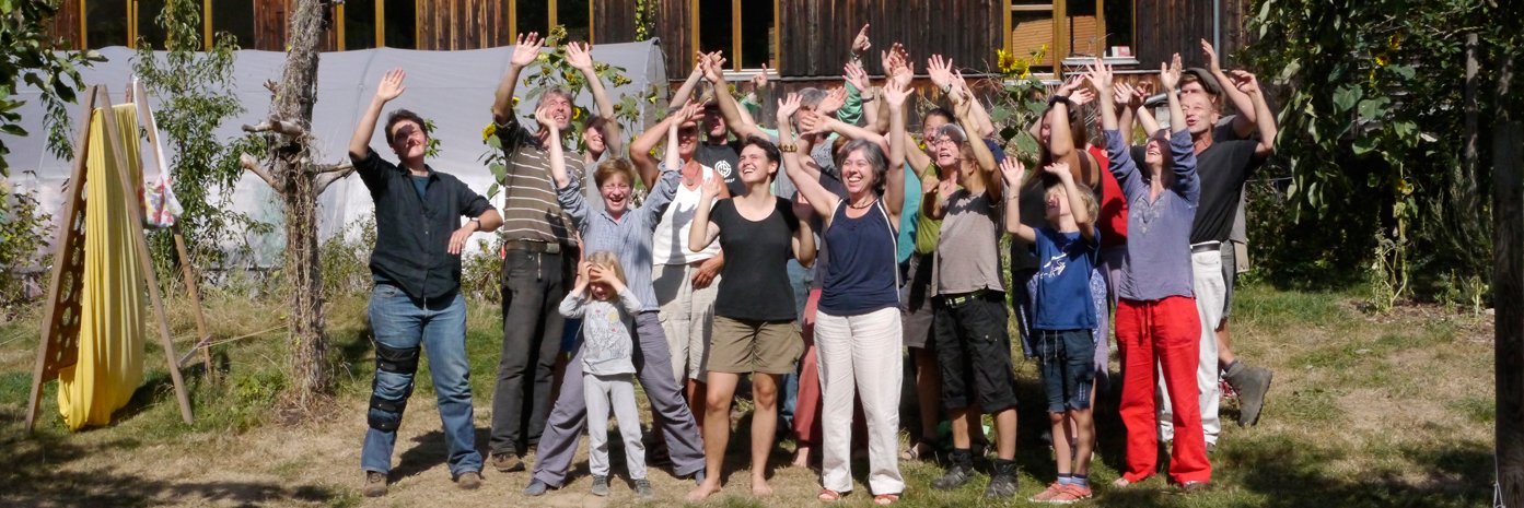 Gruppenfoto von circa 20 Personen, die mit erhobenen Armen jubeln.