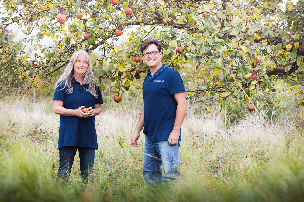 Frau und Mann vor Apfelbäumen